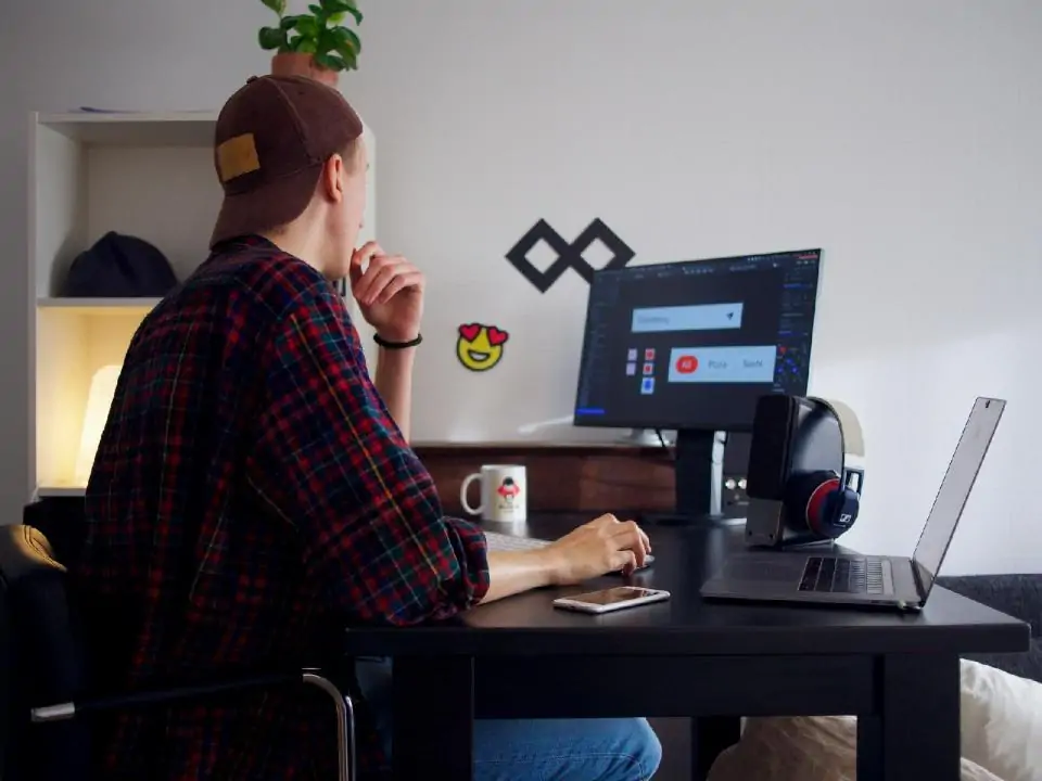 Personne travaillant sur ordinateur à un bureau.