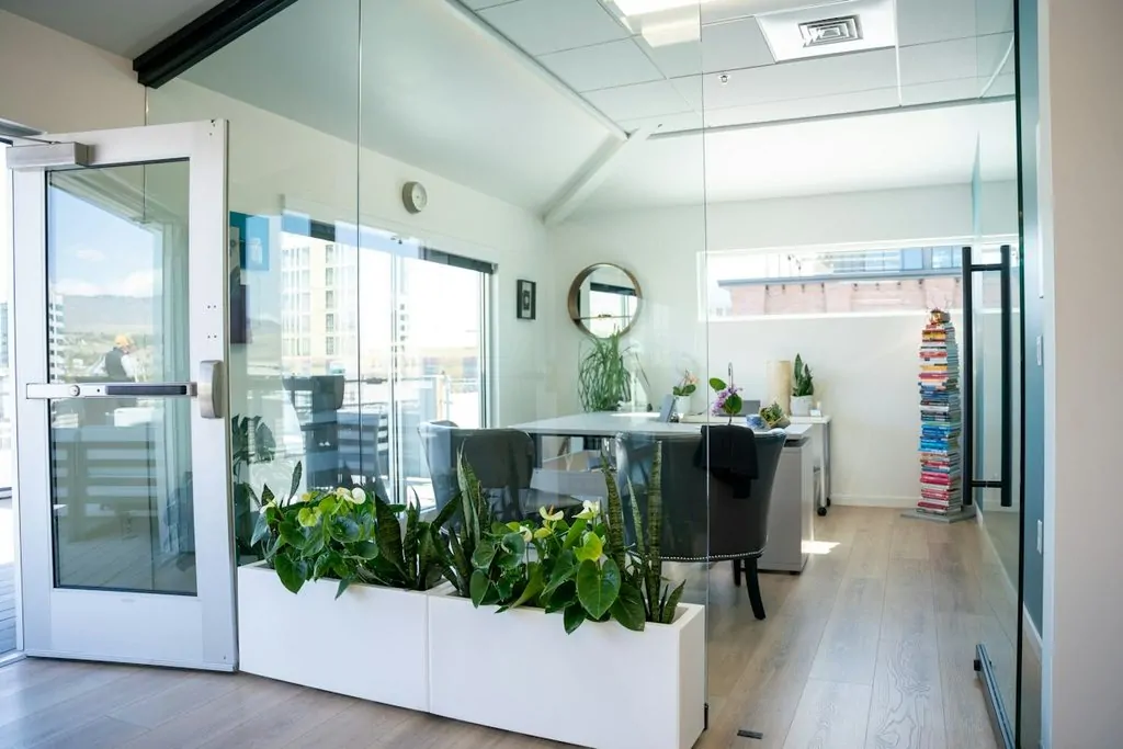 Bureau moderne vitré avec plantes et mobilier élégant